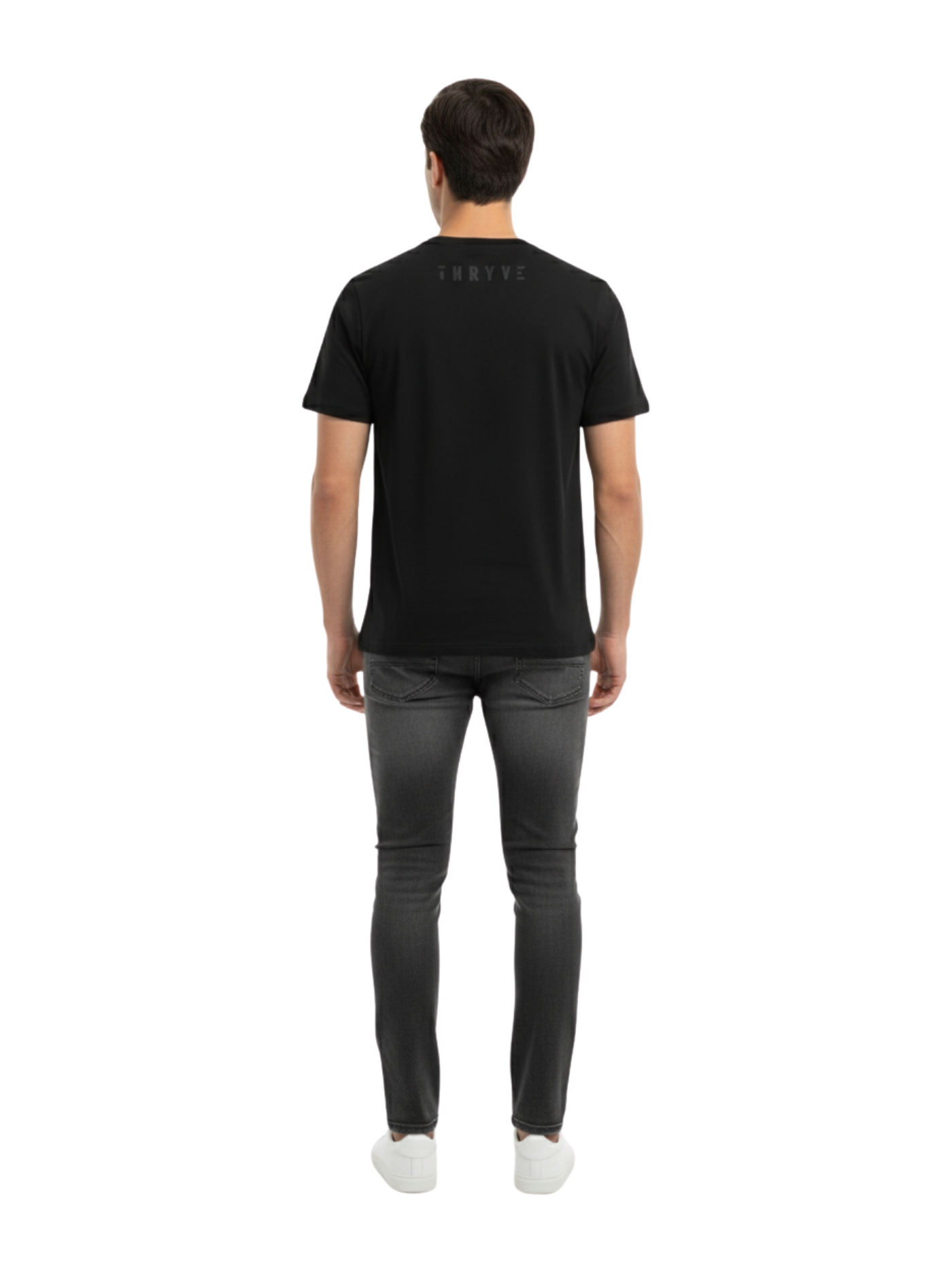 Man wearing a black t-shirt and dark jeans on a white background