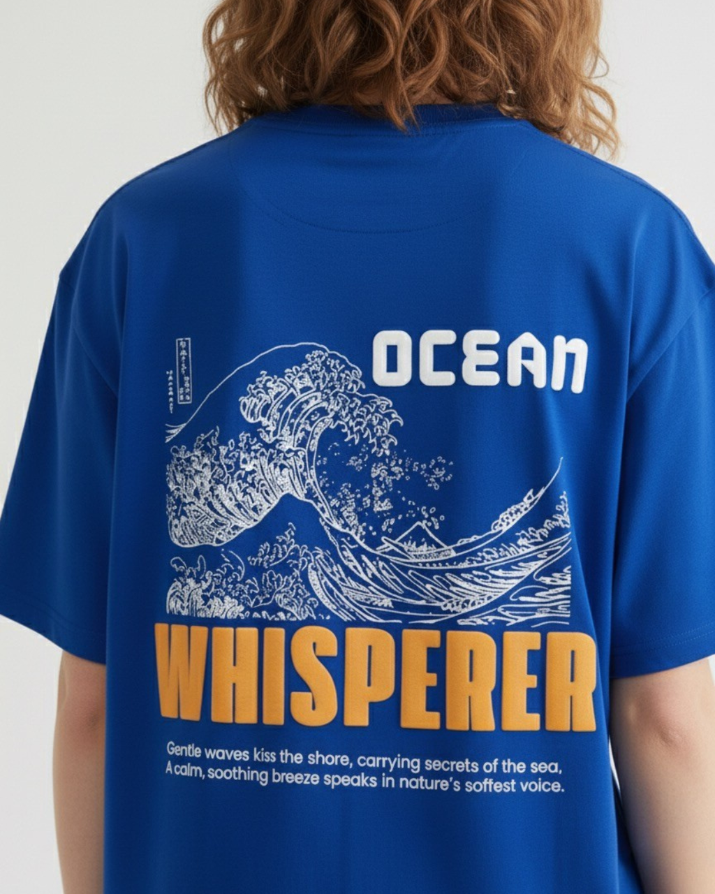 Blue t-shirt with ocean-themed design and text on a plain background