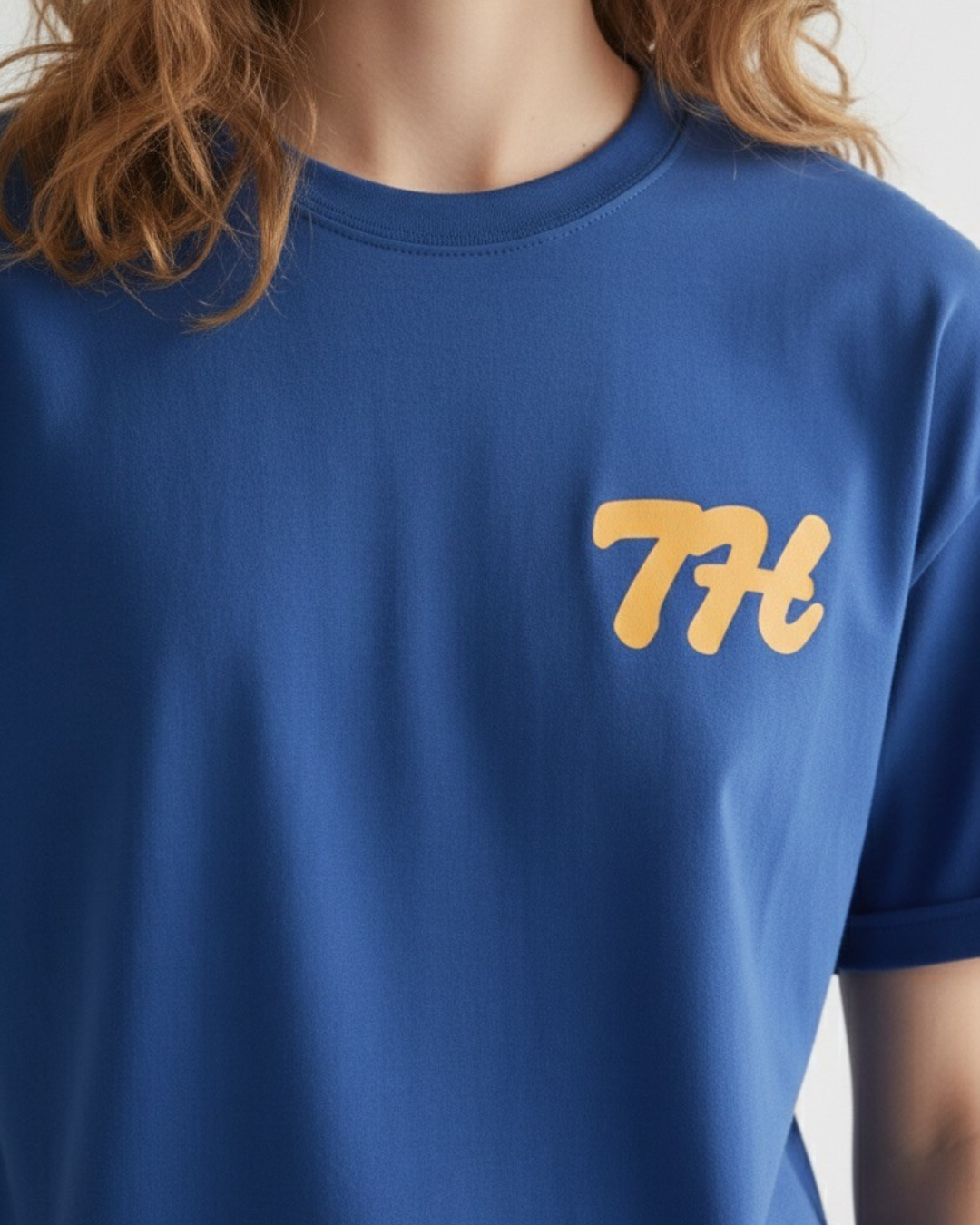 Blue t-shirt with yellow logo worn by a person